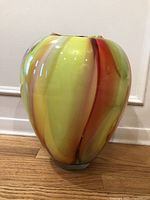 Front view of the multicolor Murano hand blown art glass vase showing yellow, orange, red and green stripes.