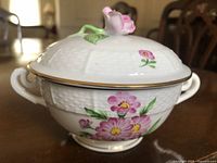 Side angle showing floral design, textured surface, gold trim, and handle