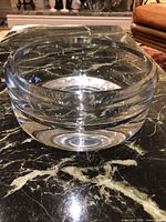 Front side view of clear glass bowl on marble surface