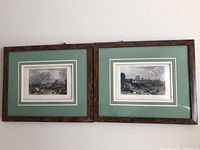 Pair of framed hand-colored engravings depicting scenes of Saumur, France, showing wood frames with green matting and double white inner mats