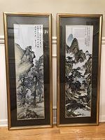 Two framed Chinese Kesi tapestries side by side leaning against a wall, showing full view and scale