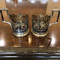 Pair of tea glass holders displayed on table showing front openwork design