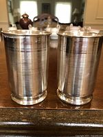 Front view of two cylindrical pure silver cups showing lathe-turned ridges