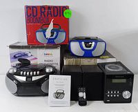 Photo showing the Proscan boombox radios and Bluetooth CD micro system with boxes, remote control, and manual.