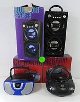 Photo showing the two Proscan Bluetooth speakers and two Proscan CD radio boomboxes with their boxes.