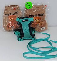 Two new small dog pet outfits in sealed plastic, brown with teddy bear and 'GOOD DAY!' print, plus turquoise adjustable Rabbitgoo dog harness with leash.