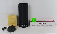 Gaming mouse with yellow box, ARGON X mouse pad cylinder container and box with green tag.
