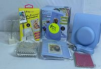 Complete kit showing blue leather case, blue photo album, DigiPower album clip and frame kit, and DigiPower accessory kit in colorful box.