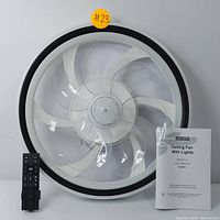 Front view of NACATIN ceiling fan showing white retractable blades, central LED light, and included remote control placed beside fan.