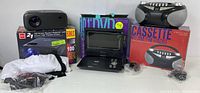Full contents of lot showing RCA projector, Proscan portable DVD player with box, Proscan cassette player with box and cables.