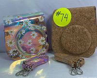 Photo showing front view of cork-textured camera bag, transparent floral-patterned bag, and matching detachable straps.