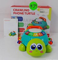 Crawling phone turtle with packaging and manual behind it