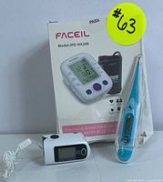 Lot showing Faceil JPD-HA200 blood pressure monitor box, fingertip pulse oximeter and digital thermometer
