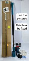 Full view of cordless pole saw with extendable pole laid flat with cardboard packaging box, battery, charger, protective gloves, and small accessories