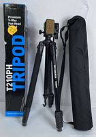 Photo of boxed Cameron T210PH tripod with carrying case beside it on a white surface.