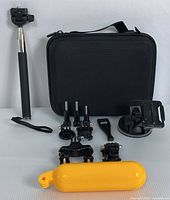 Photo of all accessories laid out showing telescopic pole, floating grip, various mounts, suction cup mount, and carry case.