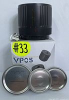 Electric mason jar vacuum sealer on its original box with a white USB cable and three metal lids of different sizes displayed in front.