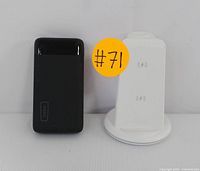 Black INIU power bank and white wireless charging stand positioned side by side with an orange label #71 visible.