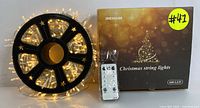 600-LED Christmas string lights on a black spool with remote control and original box.