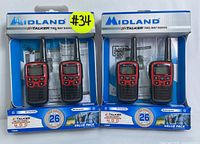 Two Midland X-Talker T31VPF two-way radio sets in original retail packaging, each containing two radios with antennas, buttons, display screens, and rechargeable capability markings. Packaging is blue and white with red accents and prominent brand logo.