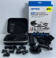 Photo showing box, hard-shell carry case with foam insert and an array of various mounts and accessories laid out on surface.