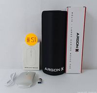Photo showing the wireless mouse with USB receiver, charging cable, Argon X Helix gaming mouse pad rolled up with its box