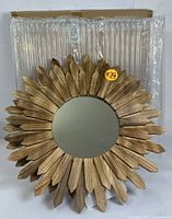 Photo of one sunburst mirror with wooden frame showing a natural rustic wood finish and round mirror in the center.
