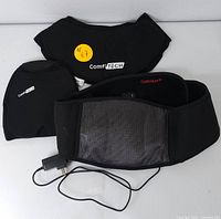 Black ComfiTECH and CUEHEAT heated therapy wraps with power cord and controls visible