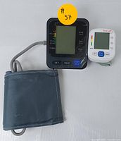 Upper arm and wrist digital blood pressure monitors side by side showing digital displays and cuffs