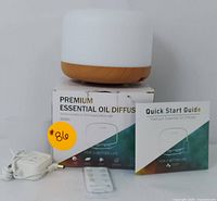 Front view of diffuser with box, remote, power adapter, and quick start guide.