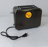 Black Seedeem toaster showing side with power cord and two bread slots on top