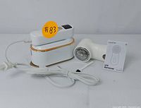 Overall view of both GAIATOP lint remover and compact mini iron including instruction manual and power cords.