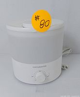 Front view of Megawise ultrasonic air humidifier with rotary dial and power cord, showing intact body and control knob.
