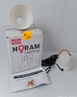 Noram Lighting wall and bathroom vanity light box, light fixture, mounting hardware, and instruction manual arranged together