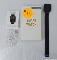 Photo showing the EarlySincere smartwatch, USB charging cable, user guide, and original white box with gold text.