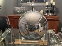 Mirrored Lucite globe lamp with a reflective surface.