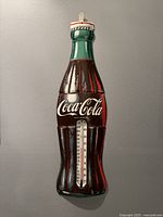 Full view of the 29-inch tall Coca-Cola bottle shaped metal sign with thermometer.