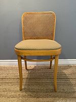 Front view of vintage bentwood caned chair showing beige cushioned seat and cane backrest.