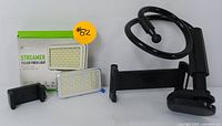 DigiPower Streamer 112 LED video light, phone holder with flexible clamp mount, original packaging, and included accessories displayed on white background.