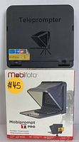 Folded teleprompter in closed black casing next to its original retail box showing product image and branding.
