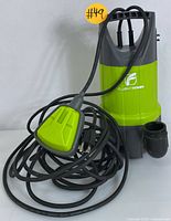 Front view of the FluentPower submersible utility pump showing the lime green and gray body with attached black power cable and float switch.