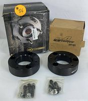 Two black metal suspension spacers with mounting hardware in packaging boxes labeled GA Supply and Dodge.