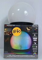Photo of the Monster Smart Illuminessence RGBW+IC Orb Light in original box showing product branding and features.