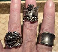 All three heavy men's rings worn on fingers showing the tiger head, bat, and plain band designs.