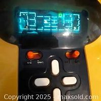 Close-up of the game's screen showing the lit-up Pacman maze and some controls underneath, highlighting the illuminated gameplay.