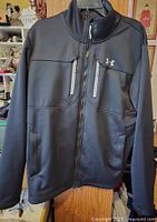 Front view of black Under Armour Infrared jacket with full zip, zippered chest pockets and side pockets visible.