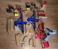 Full assortment of wooden trains, track pieces, and accessories on wood floor