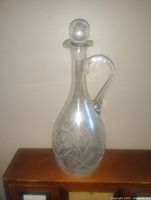 Full front view of the clear Waterford crystal decanter showing cut pattern near base and stopper on top.