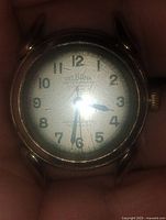 Close-up of the Delbana wristwatch showing dial with aging crazing and gold-filled case.