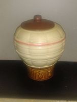 Photo of the ceramic hot air balloon cookie jar with lid on, showing front and side details and glaze colors.